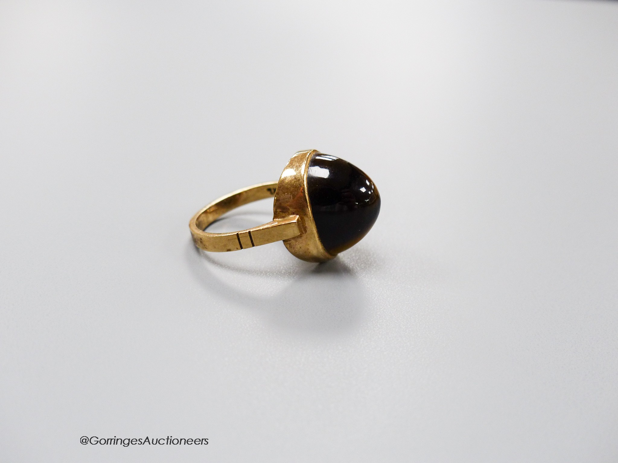 A 9ct and cabochon tiger's eye quartz set dress ring, size O, gross 5.4 grams.